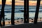 Sunset reflecting off wet sand at beach, silhouetting seagulls under a pier
