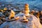 Sunset reflection on the sea beach with pebble art, small stacking stones and decorative boats made from pebble decorated with