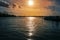 Sunset with reflections in the water in the port of the river Trave in Lubeck Travemunde at the Baltic sea, cloudy orange sky and