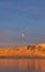 Sunset from the Reykjavik city waterfront promenade showing the full moon and the snow-capped and orange-lit islands of Engey and