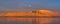 Sunset from the Reykjavik city waterfront promenade showing the full moon and the snow-capped and orange-lit islands of Engey and