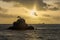 Sunset, a rock and a boat in New Caledonia