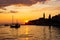 Sunset in Rovinj, Croatia, with a boat sailing in the Adriatic Sea and the sunrays reflected on the water, with the old town at