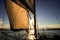 Sunset at the Sailboat deck while cruising sailing at opened sea or river. Yacht with full sails up at the end of windy