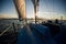 Sunset at the Sailboat deck while cruising sailing at opened sea or river. Yacht with full sails up at the end of windy