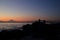 Sunset scene of rocky beach, human silhouette and Mt. Fuji, blue and orange sky background, Japanese photography