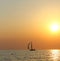 Sunset in the sea against a backdrop of a sailboat