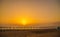 Sunset on the sea beach with sun loungers, parasols and a volley