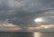 Sunset on sea with grey cloudy sky, rays of light