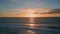 Sunset sea rippling water beach aerial view. Golden dawn sky dark serene ocean
