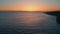Sunset sea rippling water beach aerial view. Golden sky calm marine surface