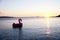 Sunset at the sea with silhouettes of boats and inflatable flaming