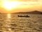 Sunset on the sea with single fishing boat in an orange scenery