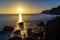 sunset in the sea with the sun on the horizon reflecting the light in the water and on the rocks on the shore. Gran Canaria. Long