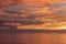 Sunset seascape, orange, blue, yellow, magenta, gold sky reflected in the sea pacific ocean, background photo of sun setting over