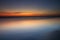 Sunset seascape. Slow shutter speed. Soft focus. Silky water. Black sand beach. Colorful sky. Amazing water reflection. Nature and