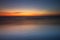 Sunset seascape. Slow shutter speed. Soft focus. Silky water. Black sand beach. Colorful sky. Amazing water reflection. Nature and