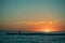 Sunset On The Seashore. Glowing Cirrus Clouds. Dark Silhouette Of A Fisherman With A Fishing Rod On A Breakwater. Appeasement.