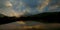 Sunset seen trees along with lake and colorful dramatic sky. Panaromic shot.
