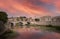 Sunset sene of St. Angelo Bridge over River Tiber in Rome, italy under red dramatic sky