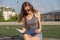 Sunset Serenade: Girl Captivated by a Magazine at the Football Grandstand