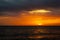 sunset and ship on horizontal ocean water surface colorful cloud