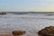 Sunset on the shores of the Atlantic Ocean near Cascais, Portugal. Oil tanker on the horizon