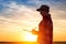 Sunset silhouette of female farmer writing notes in field