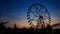 Sunset silhouette of Ferris wheel