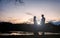 Sunset silhouette of pregnant couple by lake