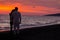 Sunset silhouette of young couple in love hugging at beach