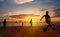 Sunset silhouettes playing beach football