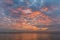 Sunset sky with orange clouds and distant boat