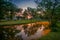 Sunset sky and yellow petals of Padauk flowers covering the pond at Phutthamonthon public park,Nakhon Pathom Province,Thailand.