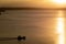 During sunset, a small barge navigates the lake
