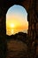 Sunset through a stone archway over the Mediterranean Sea