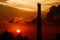 Sunset with storks on the chimney