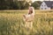 Sunset in summer.Rural life.A young woman in the field throws a hat.