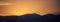Sunset/sunrise over dark mountains silhouettes
