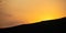 Sunset, sunrise over mountains silhouette. Scattered clouds on the sky background, space, banner.