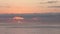 Sunset or sunrise over the sea horizon, the silhouette of a sailboat