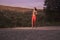 sunset sunrise, wood trees, running jogging, one young adult woman, sportswear sport clothes, outdoors, pavement road