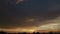 Sunset time lapse with beautiful clouds over town roofs