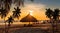 Sunset on tropical beach trees plant on sunset beach straw umbrellas tent on front sea water