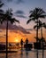 sunset tropical pool with palm trees, couple man and woman watching sunset by the pool with palm trees during vacation