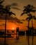 sunset tropical pool with palm trees, couple man and woman watching sunset by the pool with palm trees during vacation