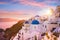 Sunset view of the blue dome churches of Santorini, Greece.