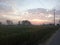 Sunset view and blue orange skyline against green field.