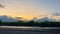 Sunset, view of the mountains from the sea at low tide, the bottom of the sea is exposed and algae and stones come out