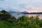 Sunset view of small boats and large merchant vessel under and near the Quebec Bridge over the St. Lawrence River